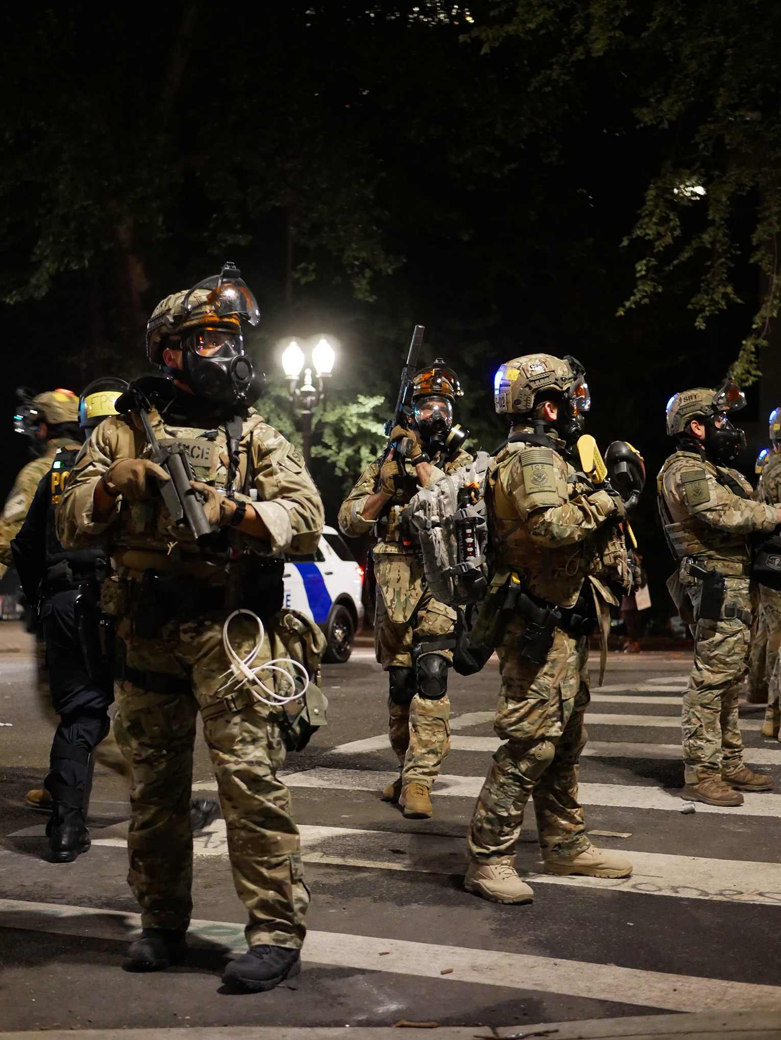 Photograph of police officers dressed in full camouflage protective gear on the streets of downtown PDX.